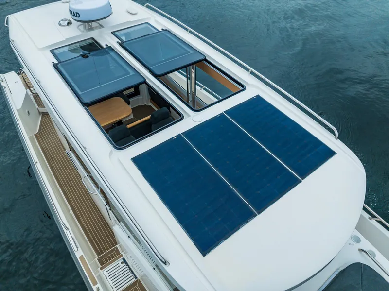 Slide: The Image of 2022 Nimbus C11 boat with solar panels on the roof, docked on water. - 33