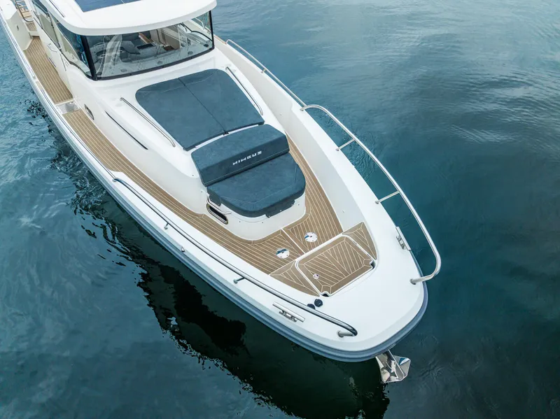 Slide: The Image of 2022 Nimbus C11 boat on calm water, showcasing sleek design and spacious deck. - 34