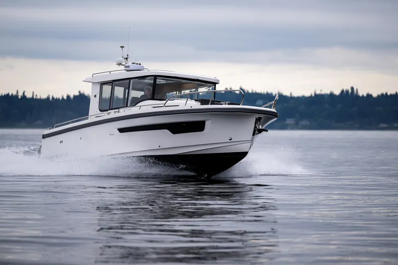 Slide: The Image of Nimbus C11 2022 boat cruising on calm water with forested shoreline in background. - 4