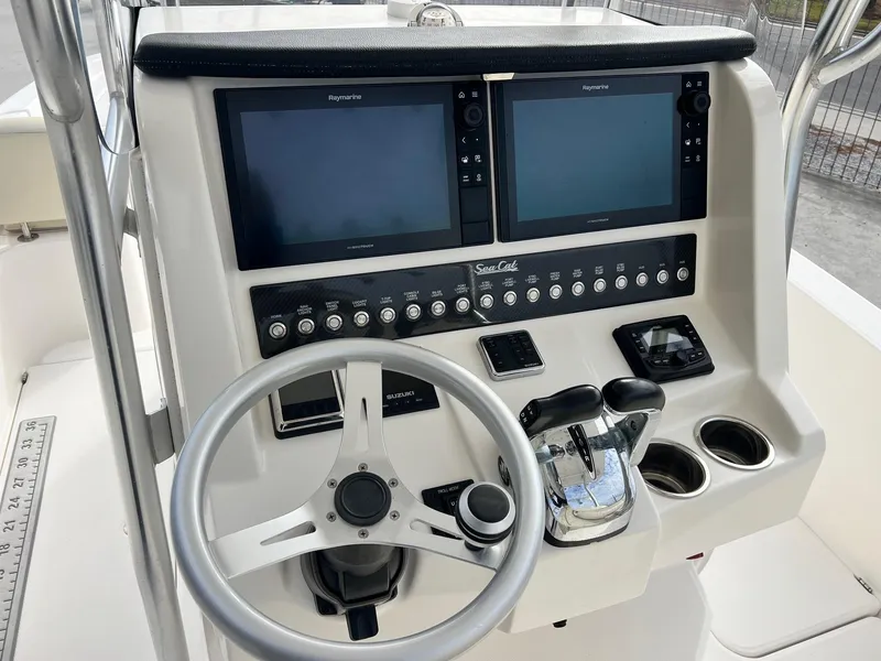 Slide: The Image of Control panel of a 2019 Sea Cat 260 boat with dual screens and steering wheel. - 14