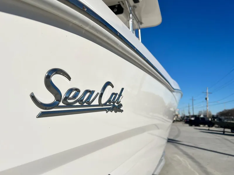 Slide: The Image of 2019 Sea Cat 260 boat, close-up of logo, parked outdoors under clear blue sky. - 2