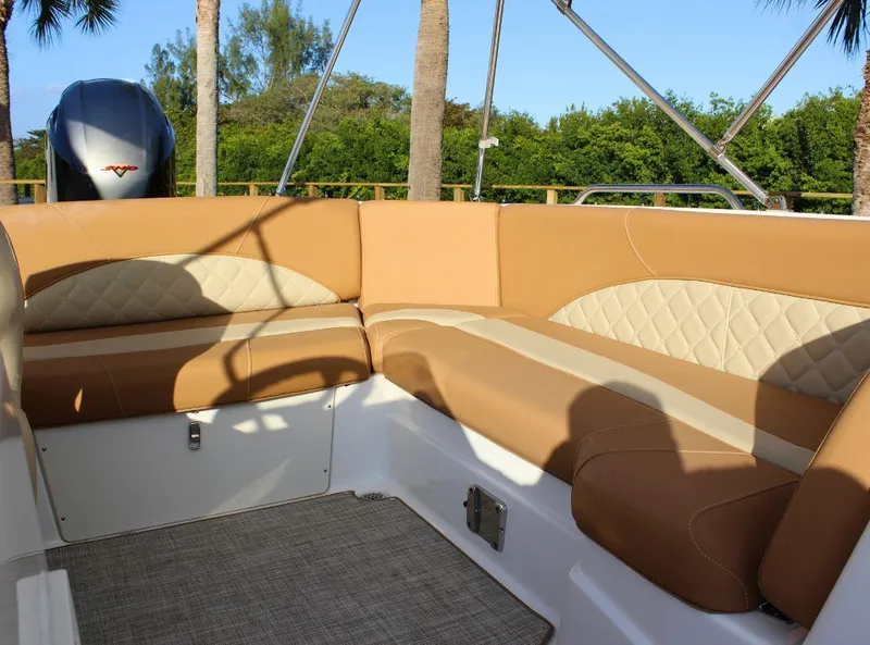 Slide: The Image of 2024 NauticStar 193 SC boat interior with tan seating and lush greenery background. - 10