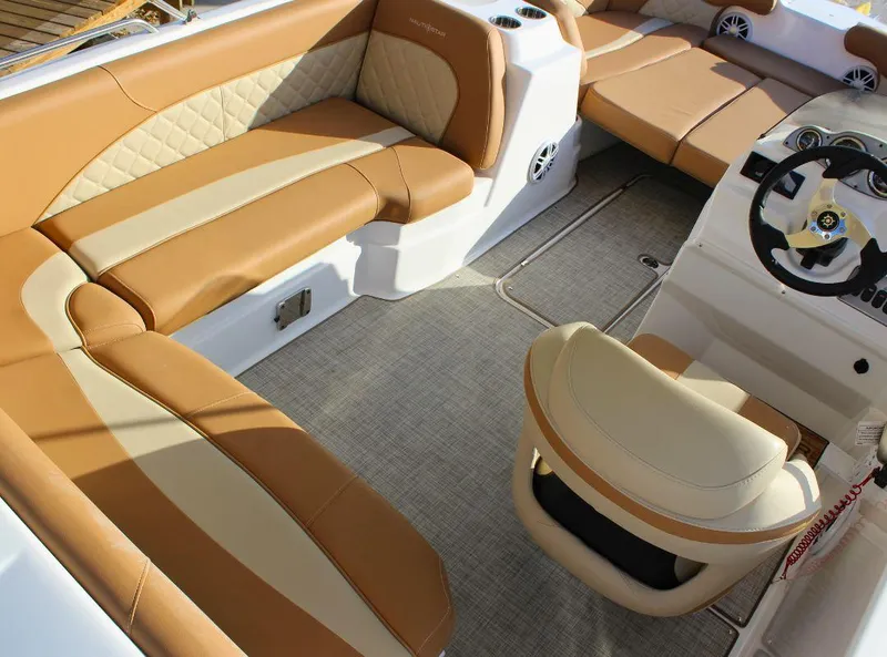 Slide: The Image of 2024 NauticStar 193 SC boat interior with tan and cream seating, steering wheel, and carpeted floor. - 7