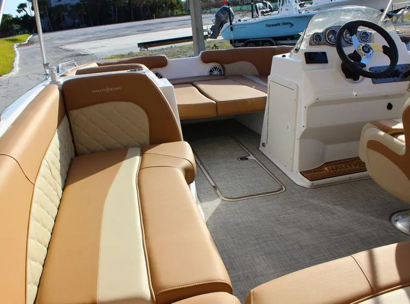 Slide: The Image of 2024 NauticStar 193 SC boat interior with tan seating and steering console. - 9