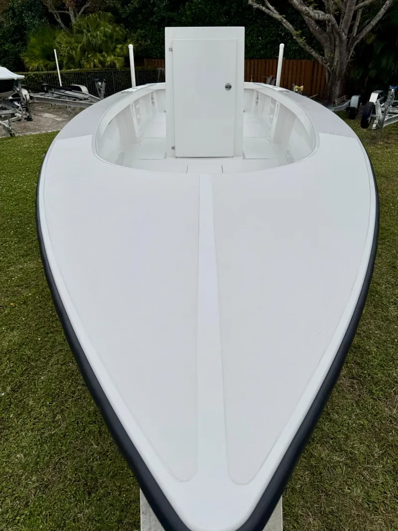 Slide: The Image of 2025 Rambo 27 boat on grass, showcasing sleek white design and spacious deck. - 14