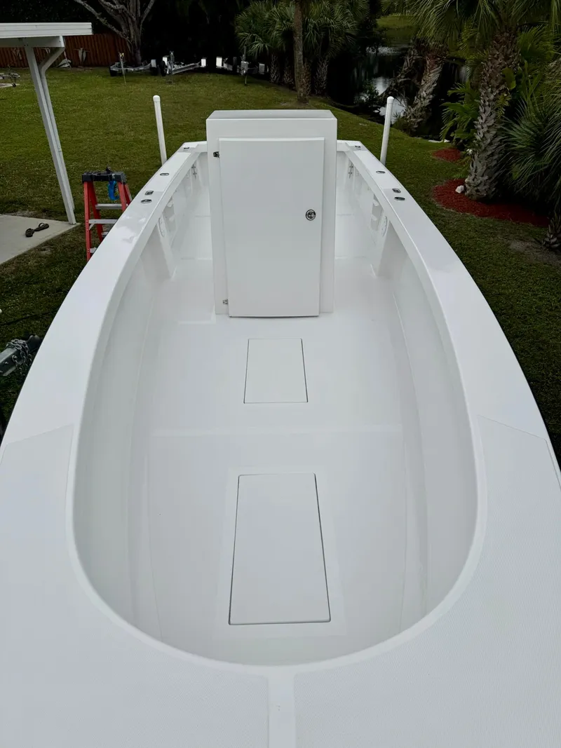 Slide: The Image of 2025 Rambo 27 boat interior, featuring a sleek white deck and storage compartments. - 15