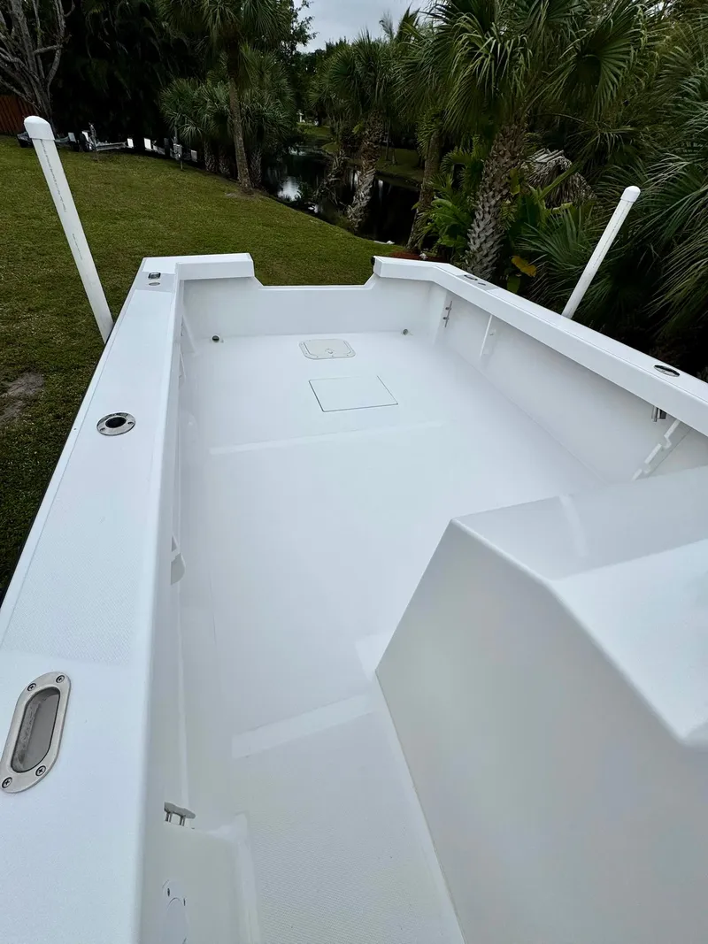 Slide: The Image of 2025 Rambo 27 boat deck, spacious and sleek design, surrounded by lush greenery. - 17