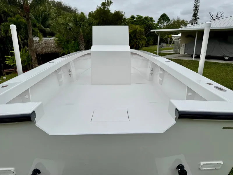 Slide: The Image of 2025 Rambo 27 boat interior, spacious white deck, surrounded by lush greenery. - 19