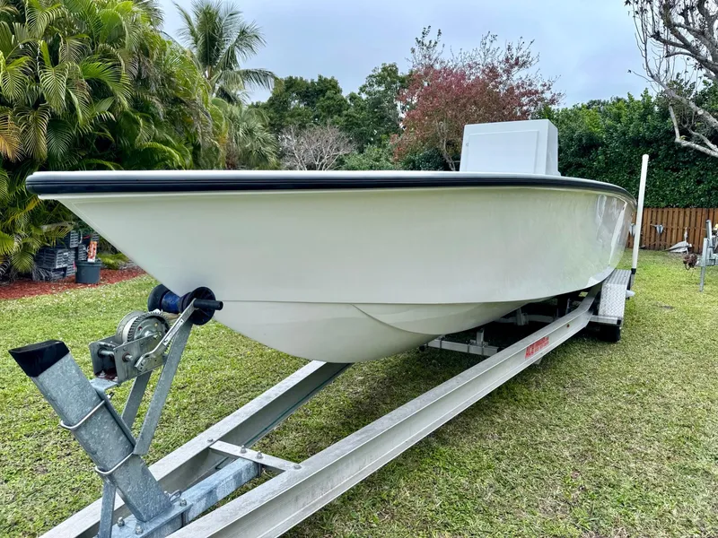Slide: The Image of 2025 Rambo 27 boat on trailer, parked on grass, surrounded by trees. - 5