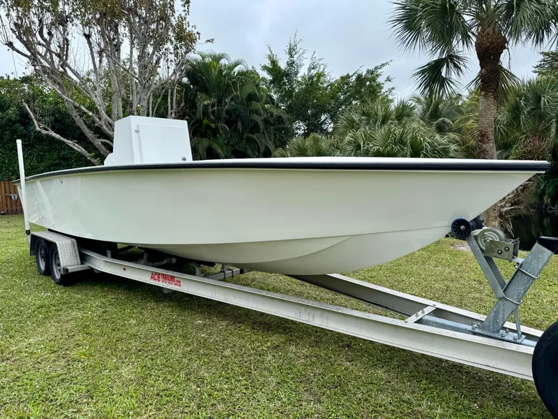 The Image of 2025 Rambo 27 boat on trailer, parked on grass with trees in background. - 0