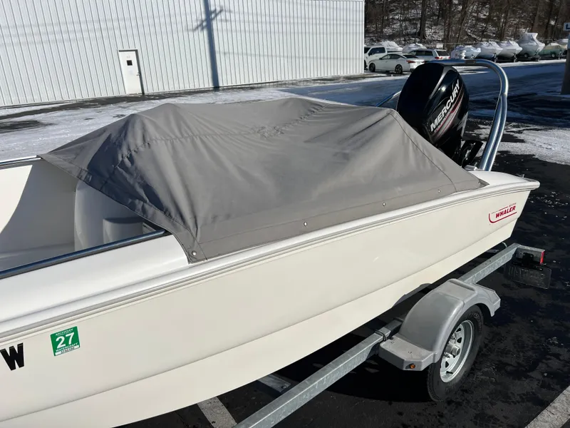 Slide: The Image of 2016 Boston Whaler 150 Super Sport boat with cover on trailer. - 10