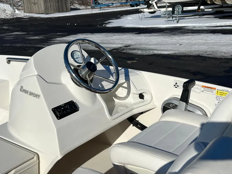 Slide: The Image of 2016 Boston Whaler 150 Super Sport boat interior with steering wheel and controls. - 13