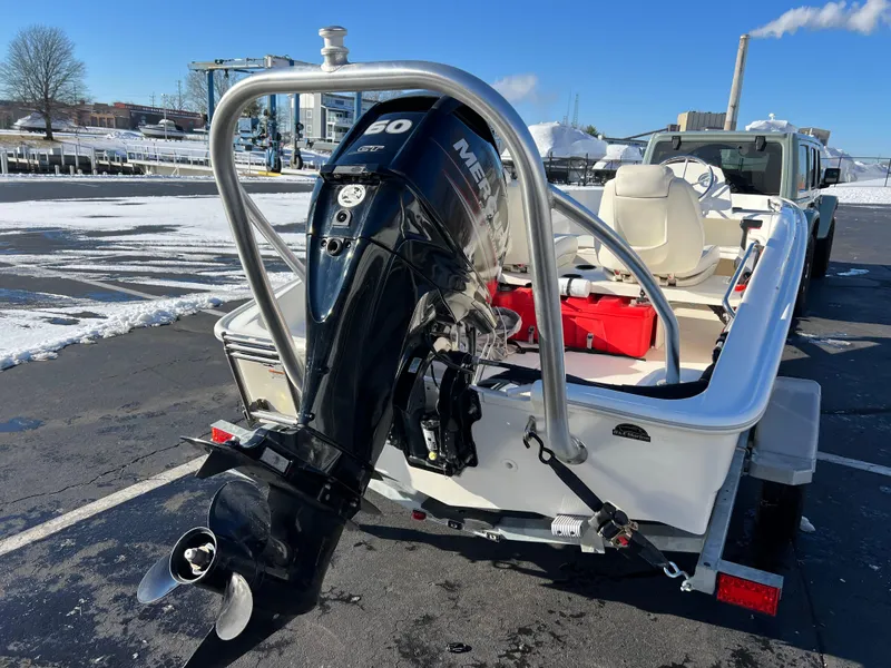 Slide: The Image of 2016 Boston Whaler 150 Super Sport boat with Mercury engine, parked on snowy pavement. - 7