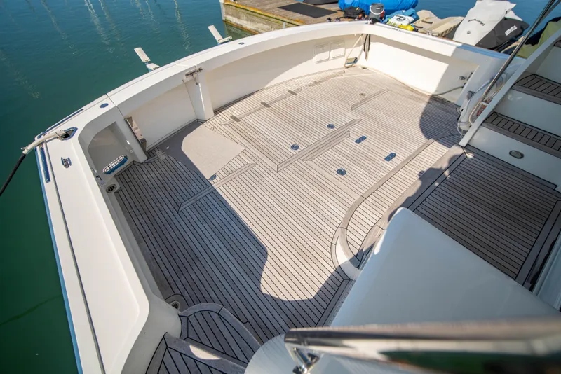 Slide: The Image of 2004 Grand Banks 58 Eastbay FB yacht deck with teak flooring and spacious layout. - 11