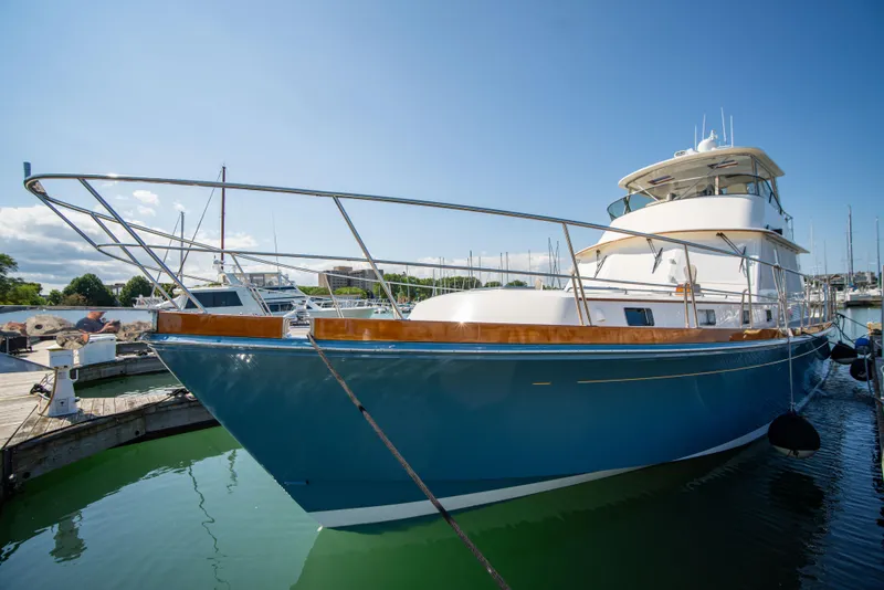 Slide: The Image of 2004 Grand Banks 58 Eastbay FB yacht docked in marina, blue hull, sunny day. - 6