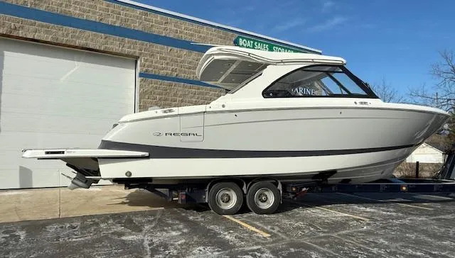 Slide: The Image of 2025 Regal LS36 boat on trailer outside a sales building. - 36