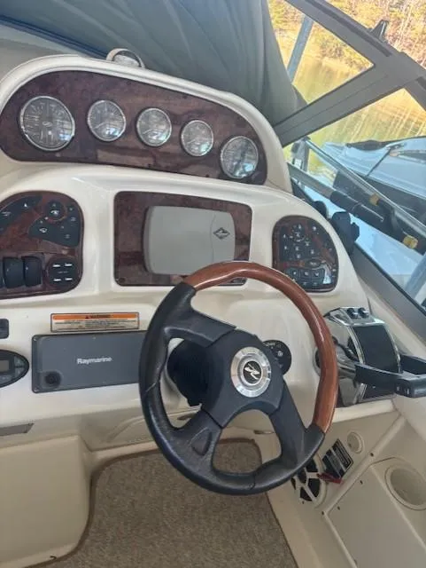 Slide: The Image of 2005 Sea Ray 300 Sundancer helm with gauges and steering wheel. - 13
