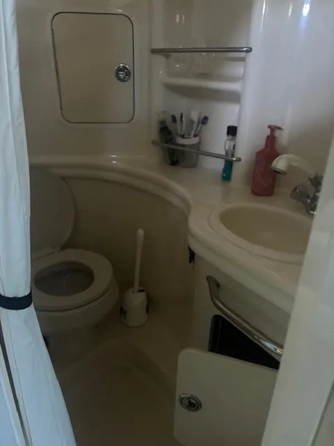 Slide: The Image of Bathroom interior of 2005 Sea Ray 300 Sundancer boat, featuring toilet and sink. - 21