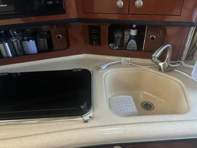 Slide: The Image of 2005 Sea Ray 300 Sundancer kitchen with sink, faucet, and countertop appliances. - 25