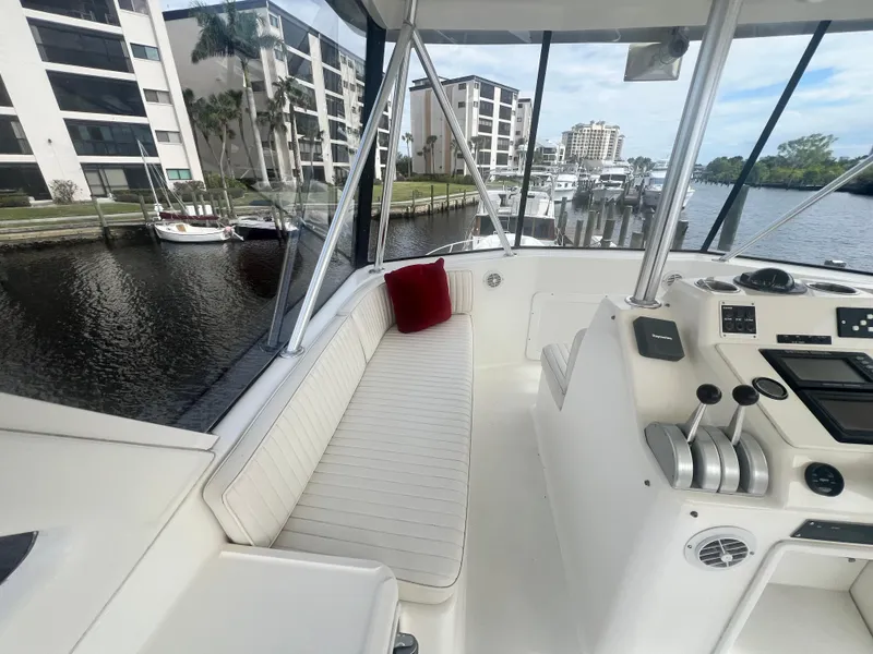Slide: The Image of 1996 Ocean Yachts 48 Super Sport interior with helm, white seating, and marina view. - 11