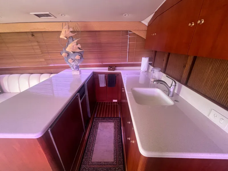 Slide: The Image of Interior of 1996 Ocean Yachts 48 Super Sport, featuring a modern kitchen with wooden cabinetry. - 18