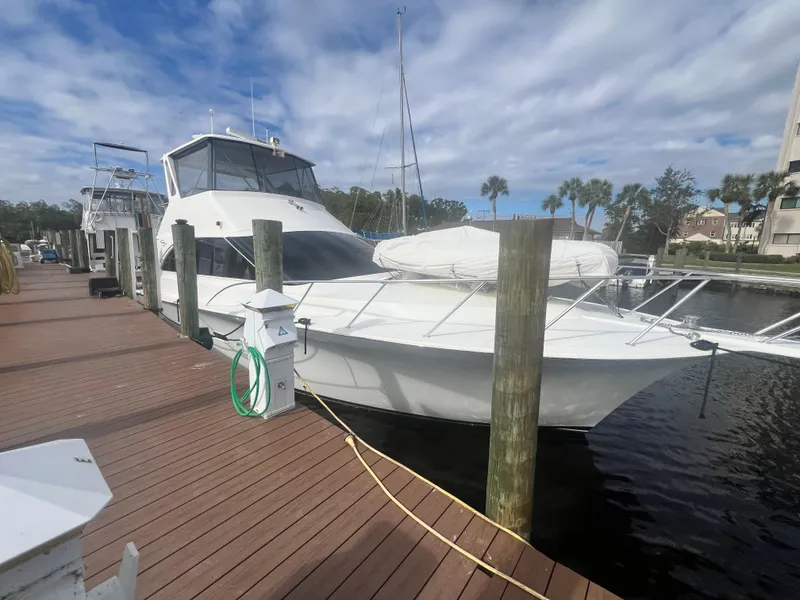 Slide: The Image of 1996 Ocean Yachts 48 Super Sport docked at marina under cloudy sky. - 2