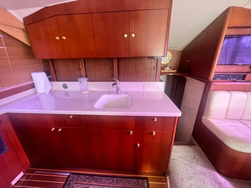 Slide: The Image of 1996 Ocean Yachts 48 Super Sport interior with wooden cabinetry and compact kitchen area. - 20