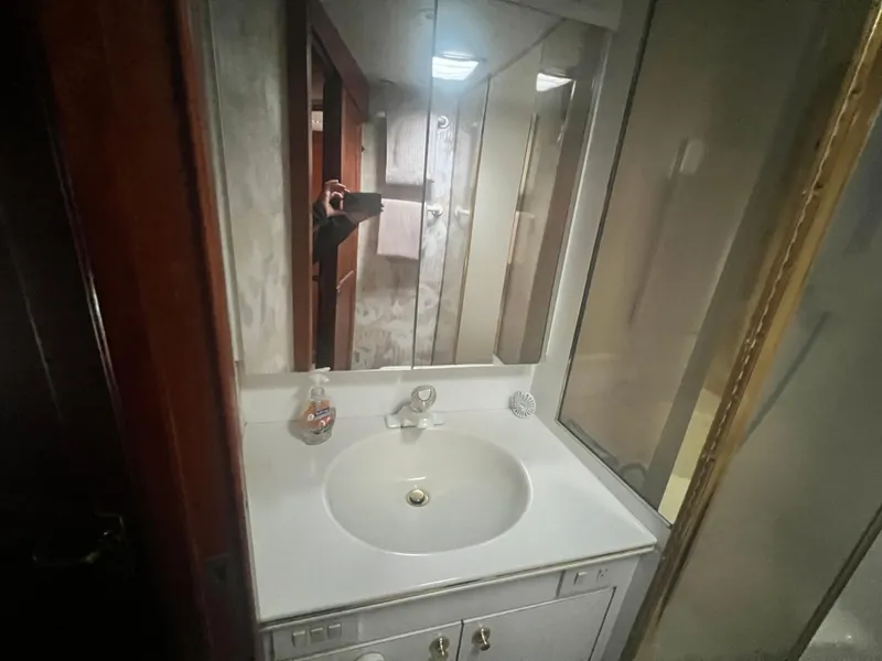 Slide: The Image of Bathroom vanity in 1996 Ocean Yachts 48 Super Sport, featuring a sink and mirrored cabinet. - 26