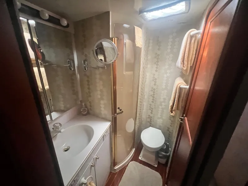 Slide: The Image of Bathroom interior of 1996 Ocean Yachts 48 Super Sport, featuring shower, sink, and toilet. - 29
