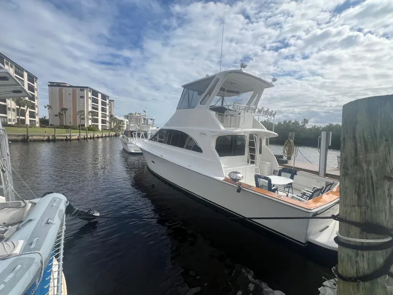 Slide: The Image of 1996 Ocean Yachts 48 Super Sport docked in a marina under a partly cloudy sky. - 3