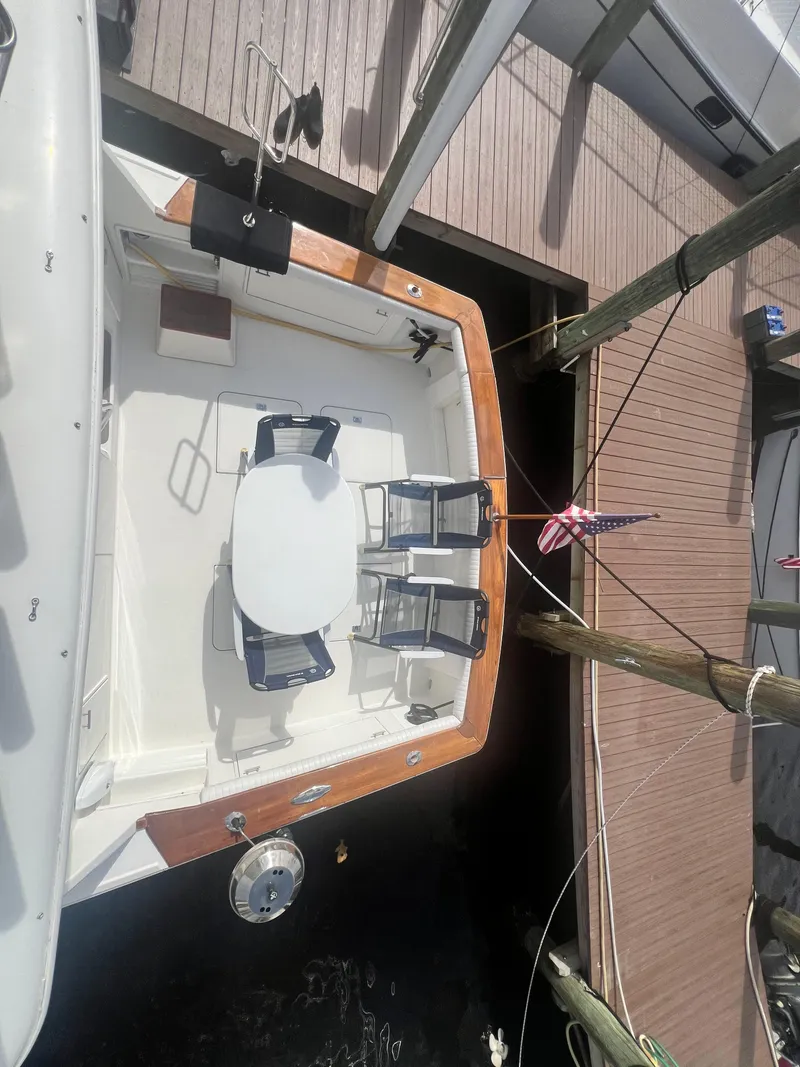 Slide: The Image of 1996 Ocean Yachts 48 Super Sport docked, featuring spacious deck with chairs and table. - 8