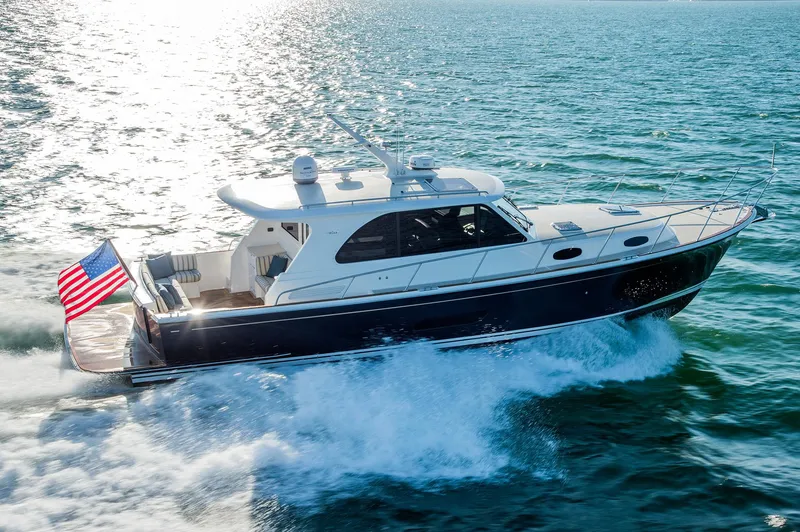 Slide: The Image of Eastbay EB44 2026 yacht cruising on open water with American flag. - 2