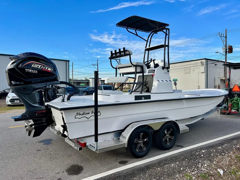 Slide: The Image of 2025 Shallow Sport 24 Sport boat on trailer with Yamaha engine, parked outdoors. - 4