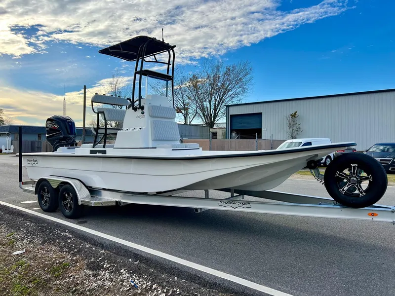 Slide: The Image of 2025 Shallow Sport 24 Sport boat on trailer, parked outdoors. - 5