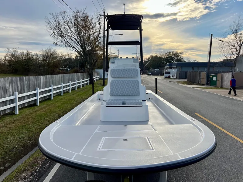 Slide: The Image of 2025 Shallow Sport 24 Sport boat on a street, under a cloudy sky. - 6