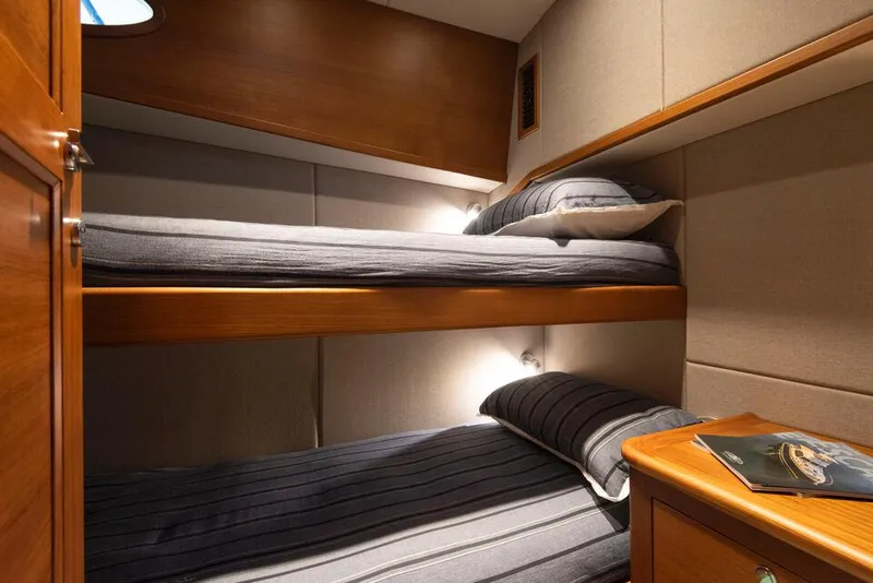 Slide: The Image of 2026 Palm Beach Motor Yachts PB65 cabin with bunk beds and wooden interior. - 11