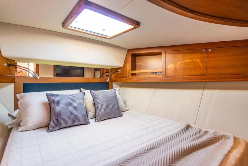 Slide: The Image of Luxurious cabin interior of 2026 Palm Beach Motor Yachts PB65, featuring elegant bedding and wood accents. - 13