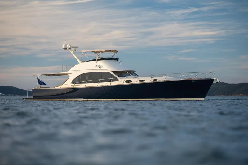 Slide: The Image of 2026 Palm Beach Motor Yachts PB65 cruising on calm waters under a cloudy sky. - 20