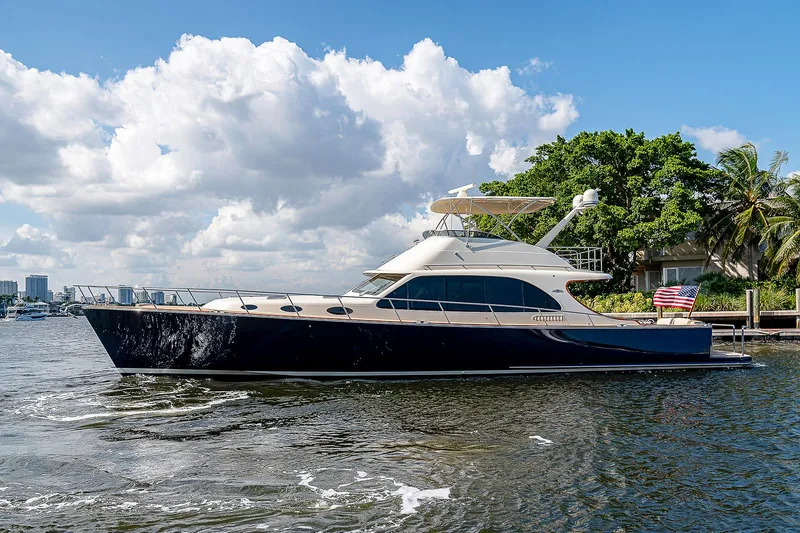 Slide: The Image of 2026 Palm Beach Motor Yachts PB65 cruising on a sunny day, with lush greenery in the background. - 23