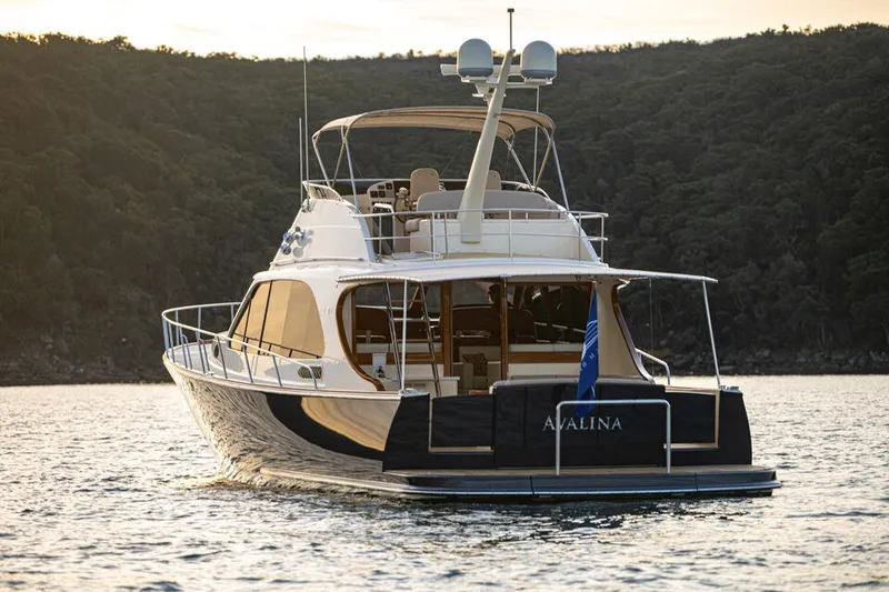 Slide: The Image of 2026 Palm Beach Motor Yachts PB65 on serene water, rear view with elegant design. - 27