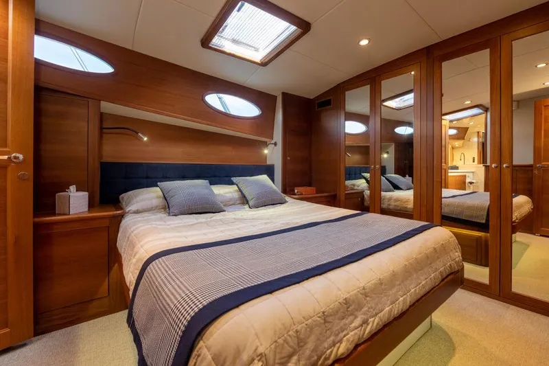 Slide: The Image of Luxurious bedroom in 2026 Palm Beach Motor Yachts PB65, featuring elegant wood finishes. - 4