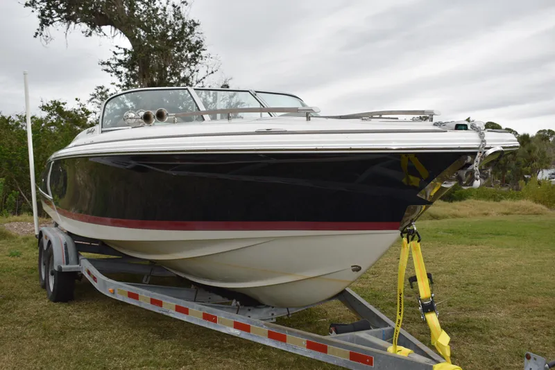 The Image of 2009 Chris-Craft Corsair 25 boat on trailer, parked on grass. - 0