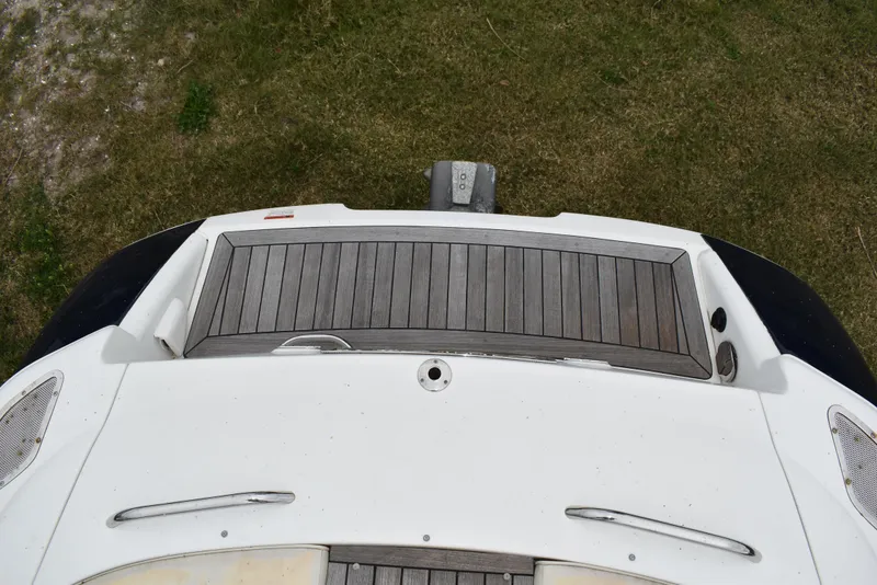 Slide: The Image of 2009 Chris-Craft Corsair 25 boat deck, featuring wooden finish and sleek design. - 10