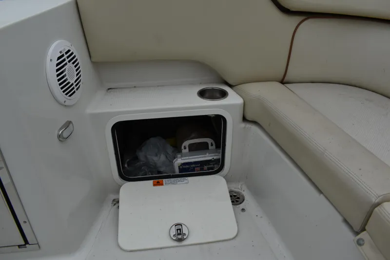 Slide: The Image of 2009 Chris-Craft Corsair 25 interior storage compartment with speaker and cup holder. - 18