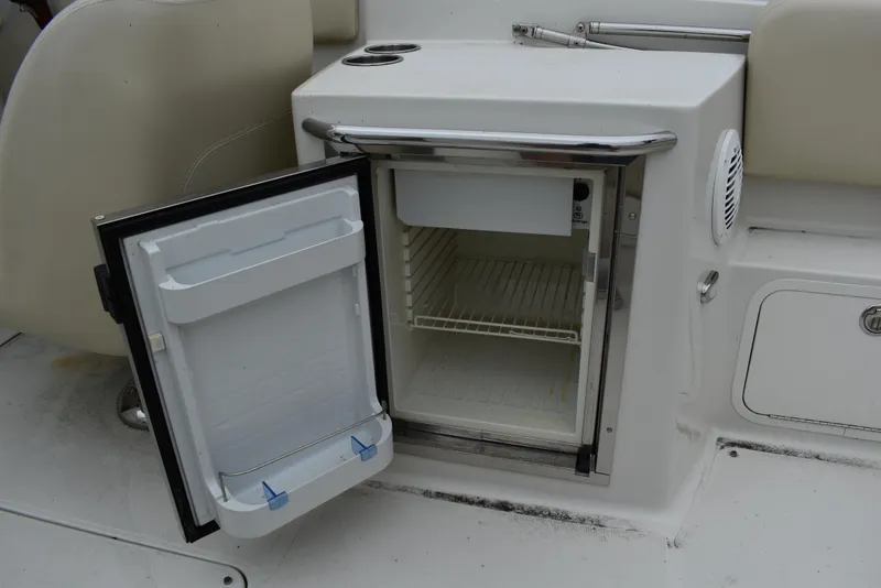 Slide: The Image of 2009 Chris-Craft Corsair 25 boat interior with open mini fridge. - 19