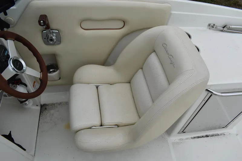 Slide: The Image of 2009 Chris-Craft Corsair 25 boat interior with white leather seat and steering wheel. - 20