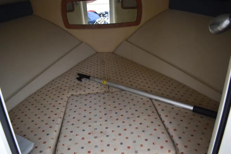 Slide: The Image of 2009 Chris-Craft Corsair 25 cabin interior with patterned upholstery and a boat hook. - 24