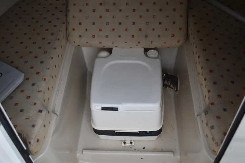 Slide: The Image of 2009 Chris-Craft Corsair 25 cabin interior with portable toilet and patterned seating. - 25