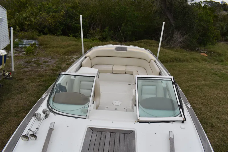 Slide: The Image of 2009 Chris-Craft Corsair 25 boat with open cockpit and seating, parked on grass. - 30
