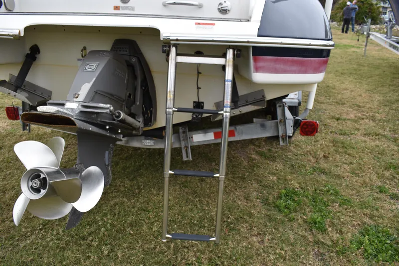 Slide: The Image of 2009 Chris-Craft Corsair 25 boat stern with ladder and propeller on grass. - 8